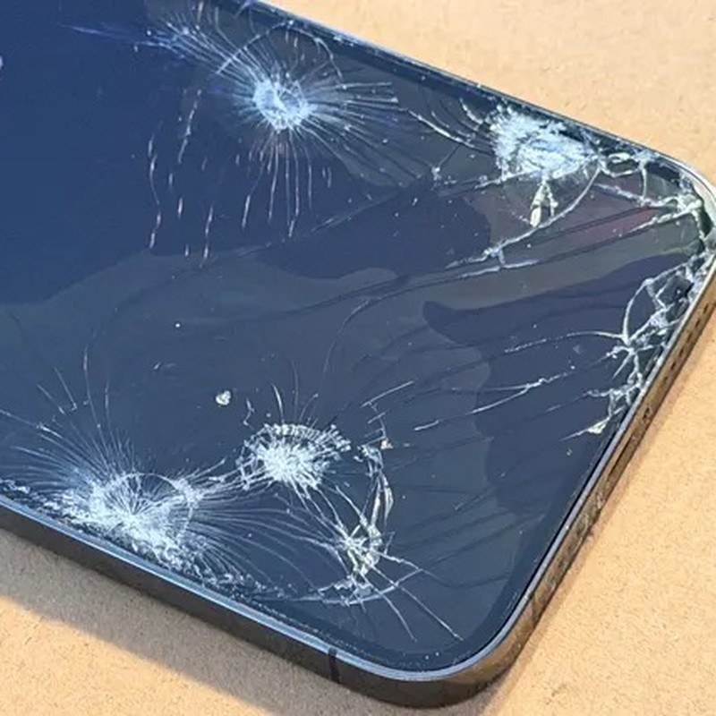 An iPhone screen with impact cracks across the glass.